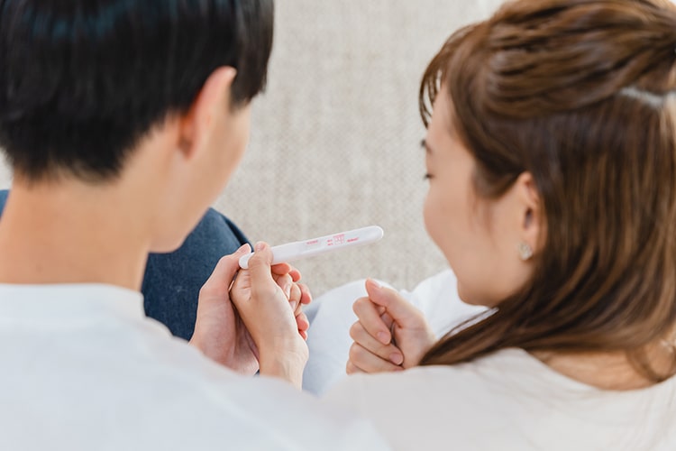 妊娠検査薬を確認するカップル